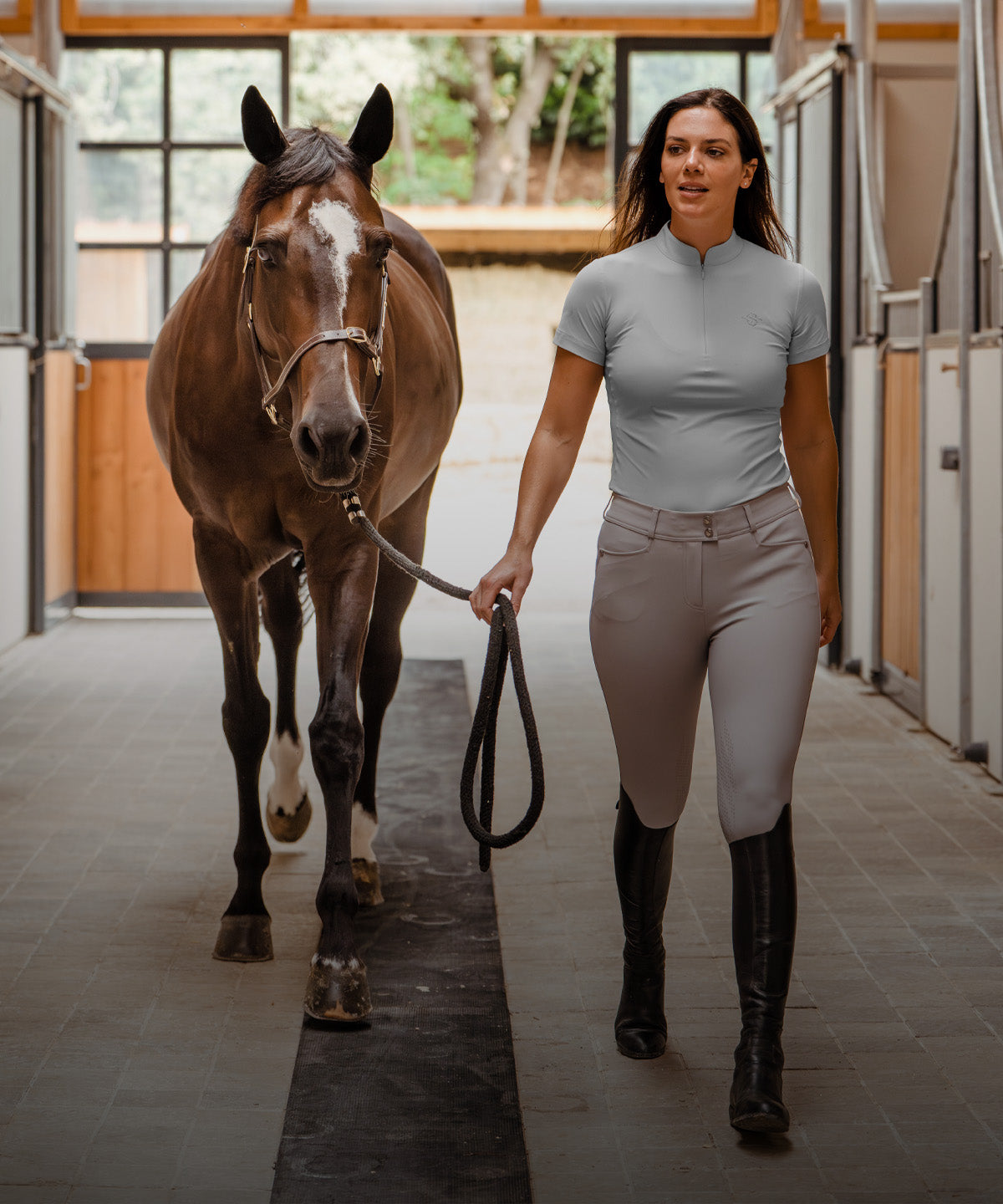 Woman Wearing Samshield Horse Riding Outfit Leading Horse